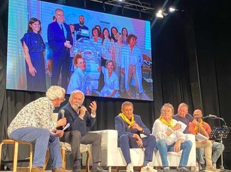 Ezio Greggio, Enzo Iachetti e Antonio Ricci sul palco, di fronte alla foto che ha emozionato Greggio. (Instagram) - Metropolinotizie.it